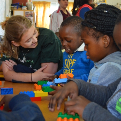 A volunteer works with young children on a high school summer travel programme abroad A volunteer works with young children on a high school summer travel programme abroad